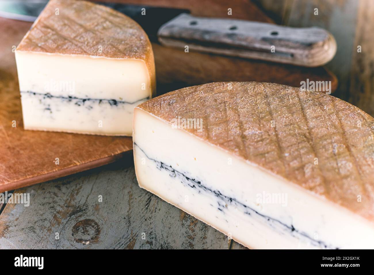 Rustico foderato di frassino e sciroppo di formaggio lavato su pannelli di legno con coltello Foto Stock