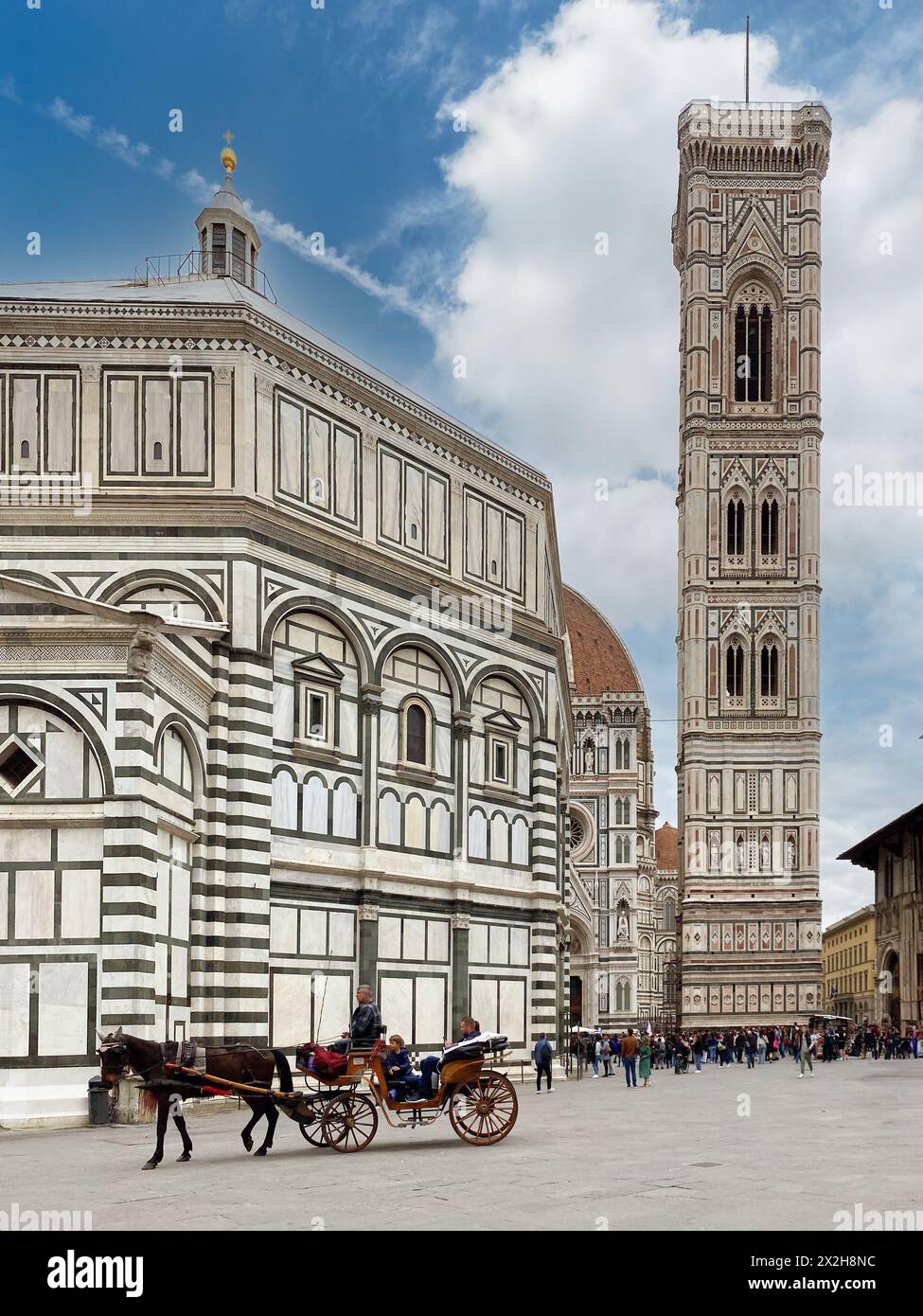 Firenze, Italia - 4 aprile 2024: Piazza San Giovanni con carrozza per turisti vicino al battistero e con il campanile di Giotto nel dorso Foto Stock