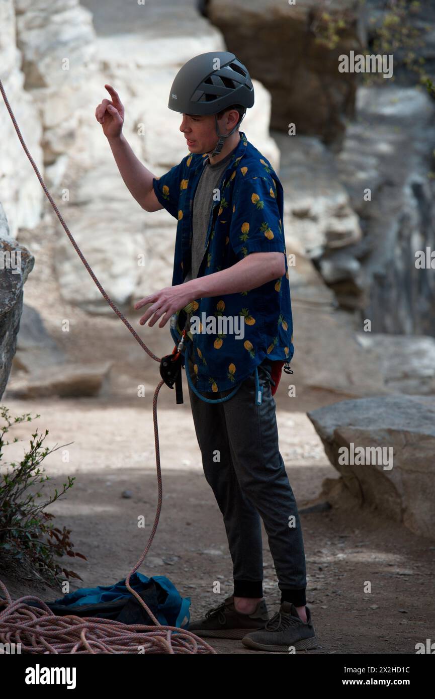 Uomo che si prepara a fare un giro con un altro scalatore che dà indicazioni sulla salita Foto Stock