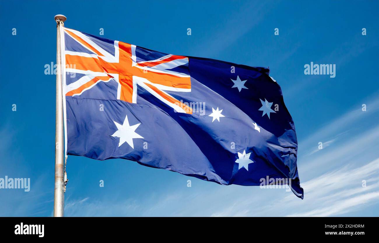 Die Fahne von Australien flattert im Wind, isoliert gegen blauer Himmel Foto Stock