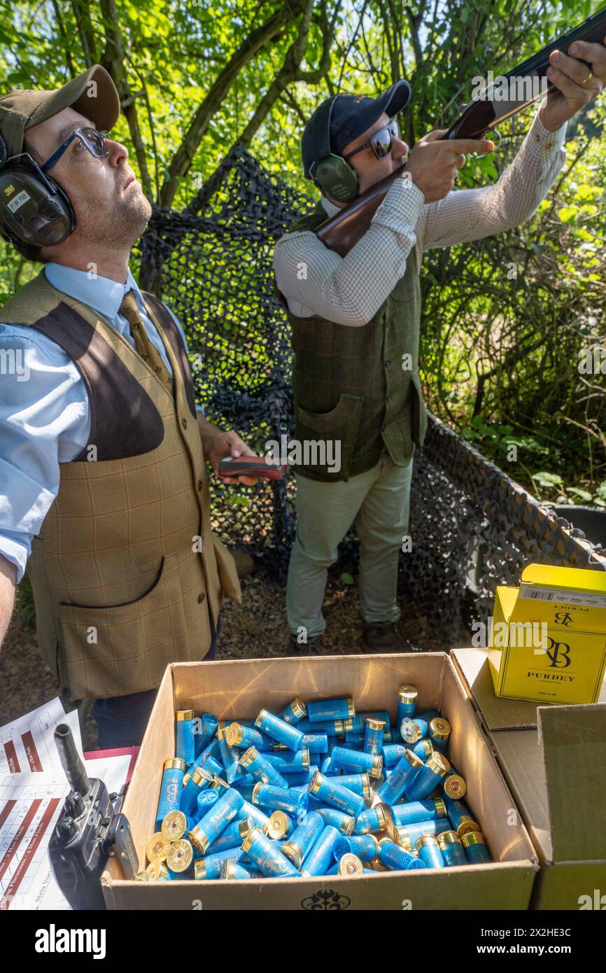 Un uomo che spara ai piccioni di argilla con una pistola a fuoco con munizioni in primo piano. Data foto: Mercoledì 24 maggio 2023. Foto: Richard Gray/Alamy Foto Stock