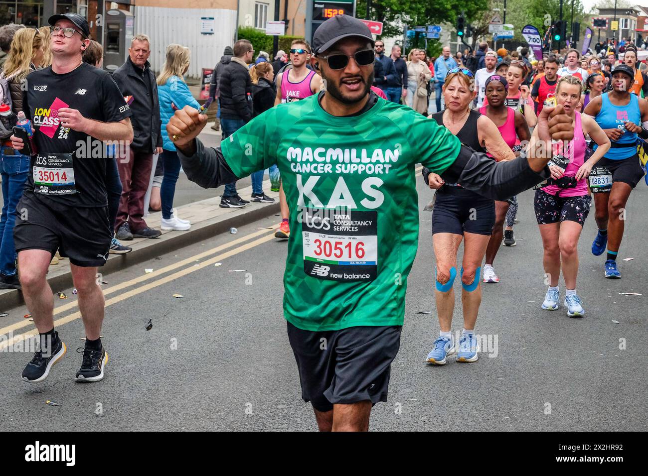 Maratona di Londra 2024: Partecipante che corre in aiuto di Macmillan Cancer Support beneficenza sulla rotta della Maratona di Londra Foto Stock