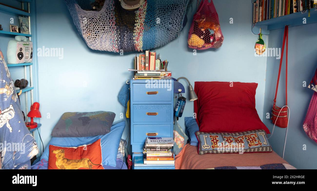 Camera interna domestica persona anziana di coppia stravagante ordinato blu camera da letto letti cuscini rete in casa Londra Regno Unito Gran Bretagna KATHY DEWITT Foto Stock