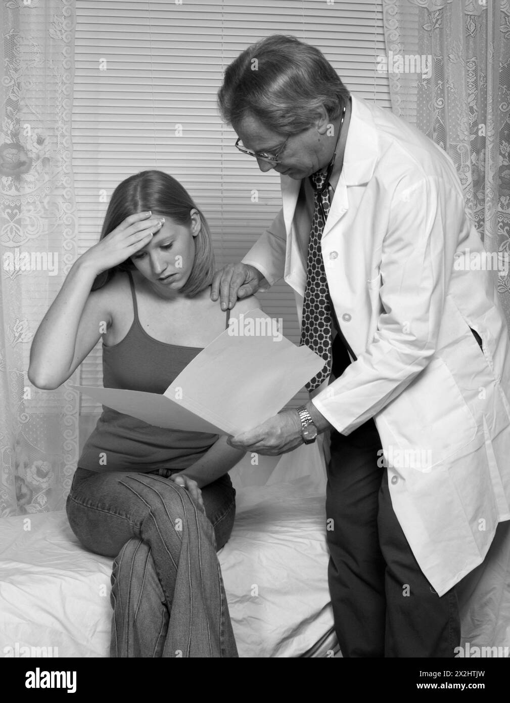 Medico caucasico maschile che esamina i risultati del paziente femminile Foto Stock