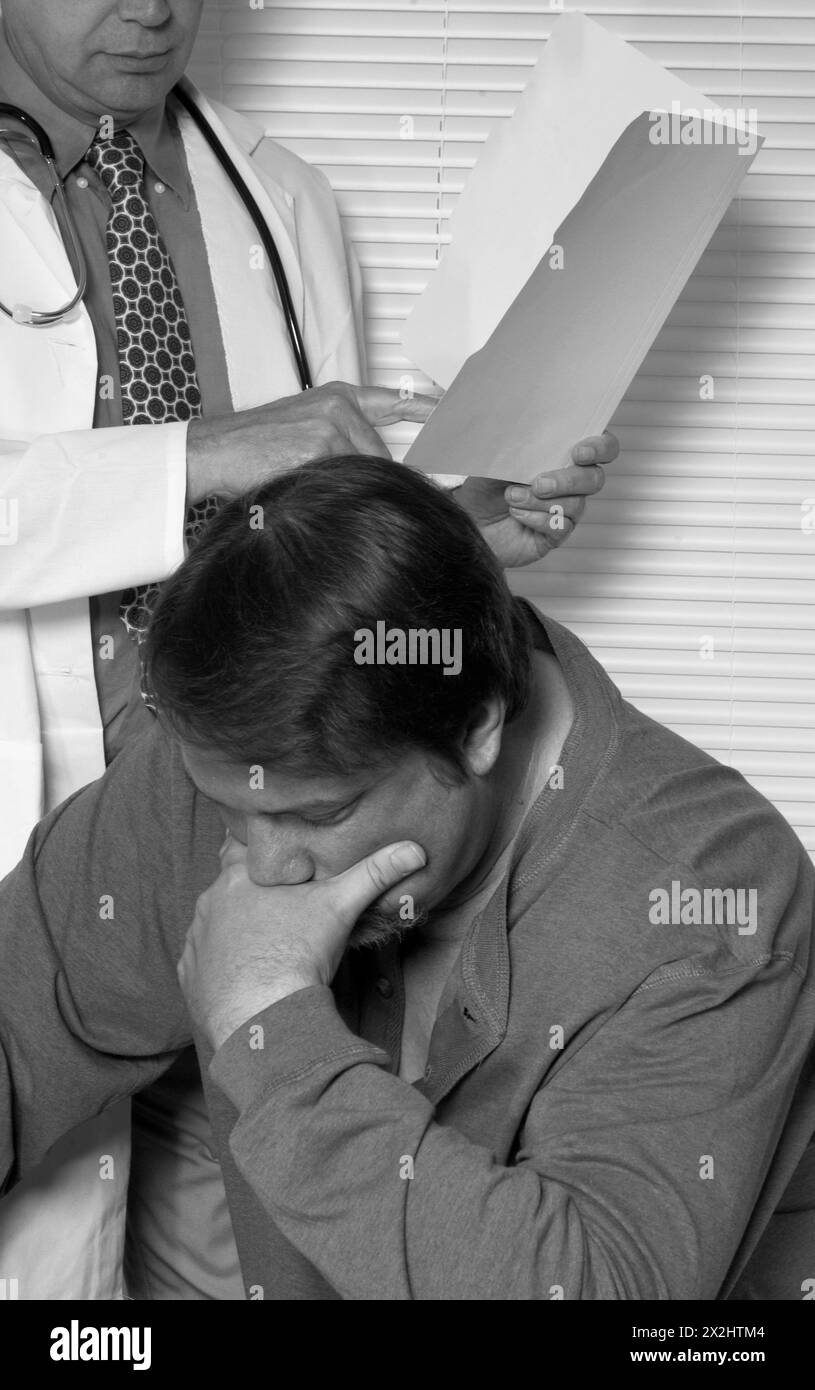 Medico caucasico maschile che esamina i risultati del paziente Foto Stock