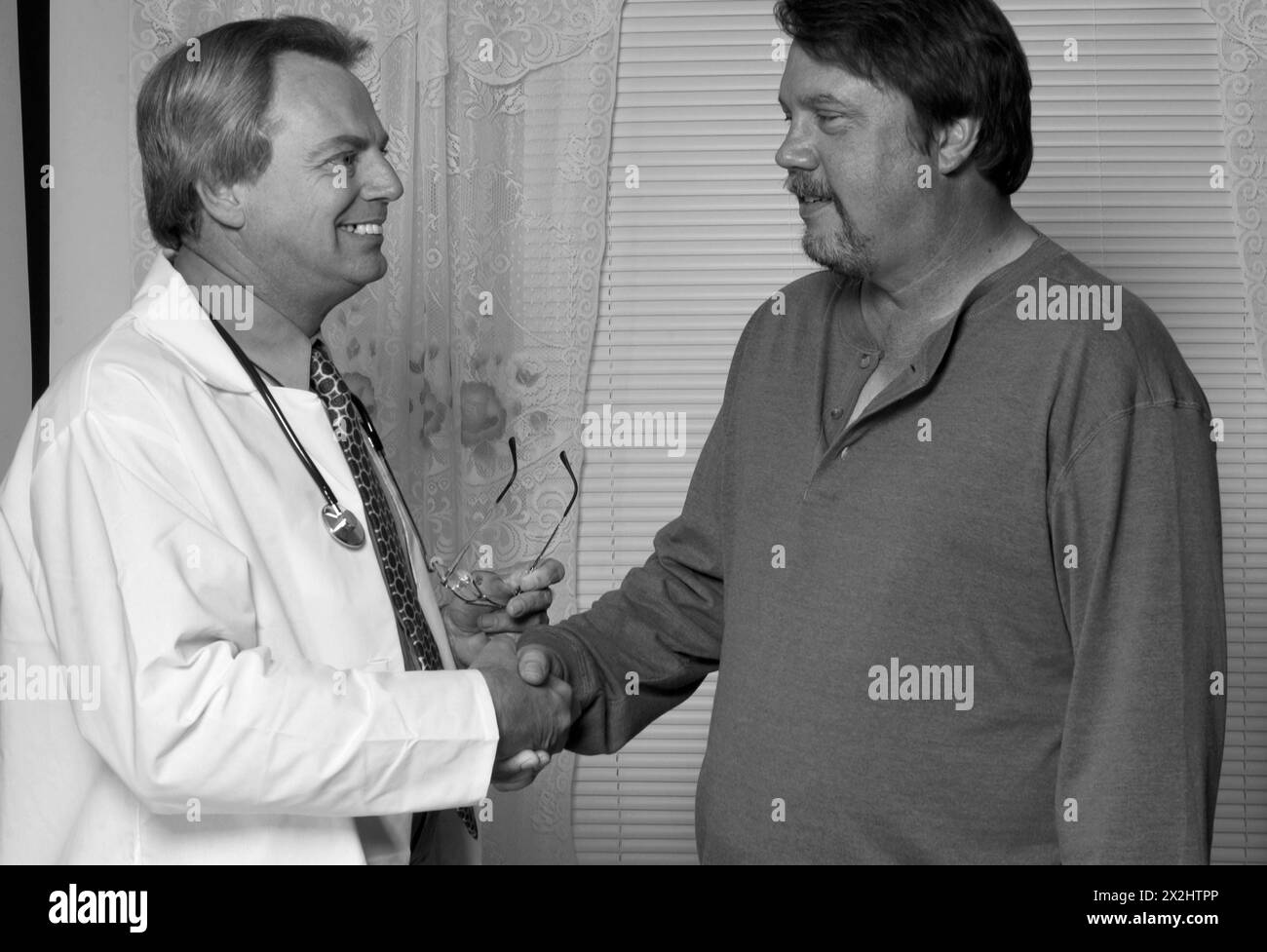 Maschio medico caucasico stringe la mano con un paziente maschio Foto Stock