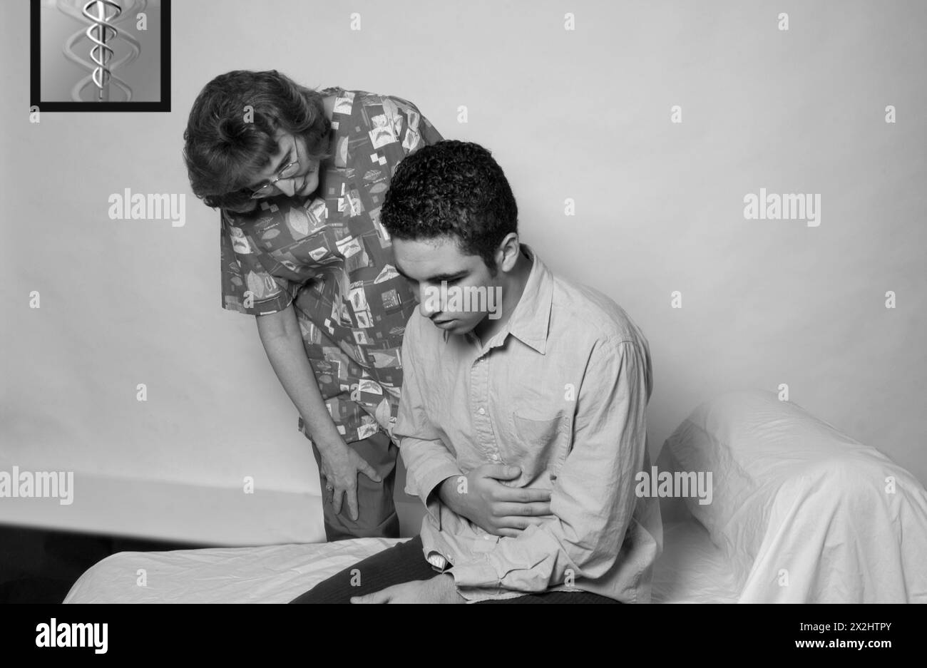 Infermiera donna che consulta un paziente di sesso maschile con mal di stomaco durante una visita medica, USA. Foto Stock