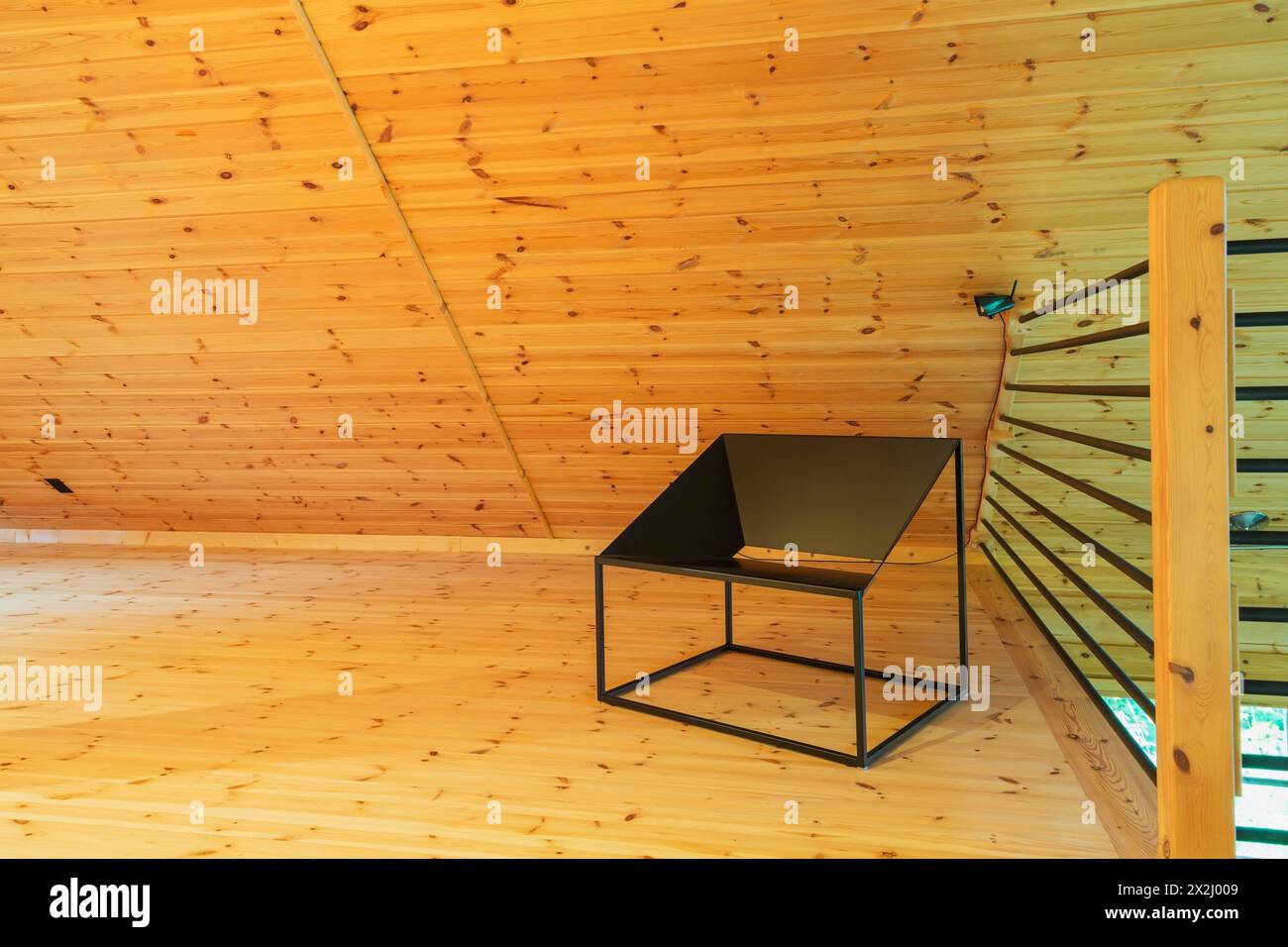 Sedia da salotto in metallo nero e ringhiere tubolari con posta in legno in home Office su soppalco all'interno di una casa in legno di pino scozzese pezzo sur Piece Foto Stock