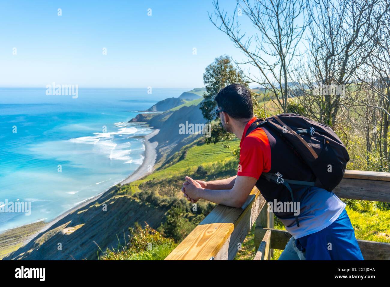 Un uomo che guarda il bellissimo paesaggio costiero nel flysch di Zumaia, Gipuzkoa. Paesi Baschi Foto Stock