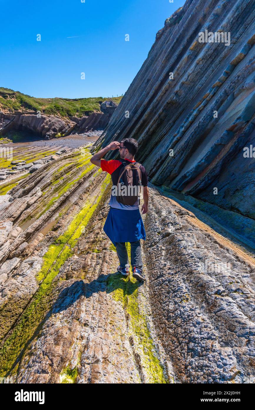 Un escursionista maschile che visita il Flysch Basque Coast geopark a Zumaia, Gipuzkoa Foto Stock