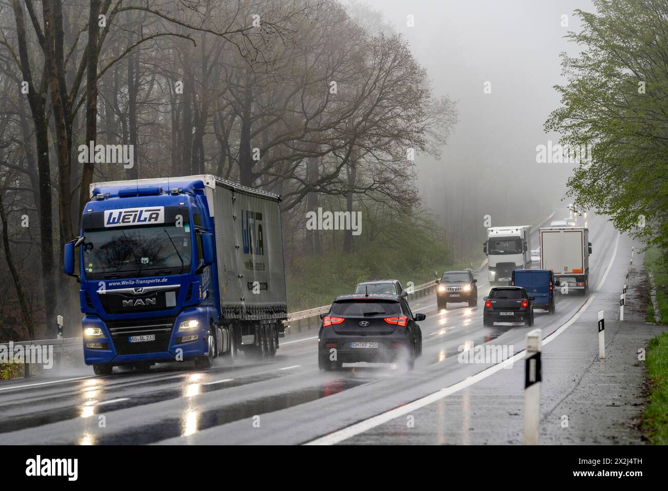 Traffico su una strada di campagna sotto la pioggia, B229, primavera, vicino a Radevormwalde, Oberbergischer Kreis, NRW, Germania, Foto Stock