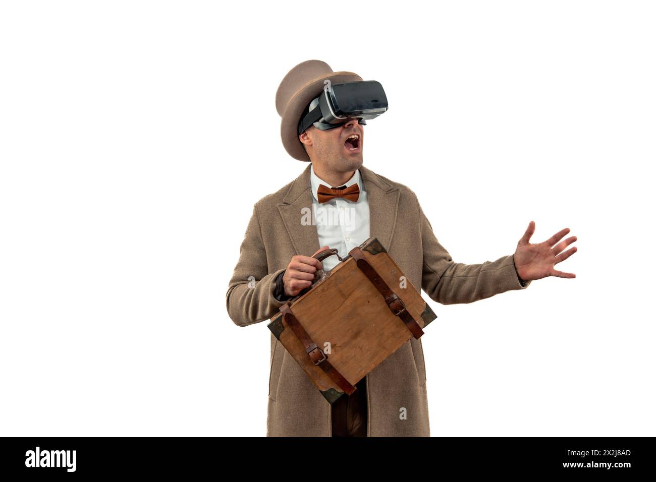 All'inizio del XX secolo, un uomo d'epoca che indossa un cappello da bowler e un trench coat, sorpreso da un'esperienza di realtà virtuale con occhiali VR retrò W Foto Stock