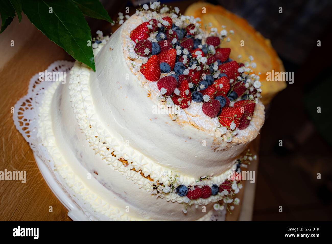 Torta nuziale cremosa con frutti di bosco Foto Stock