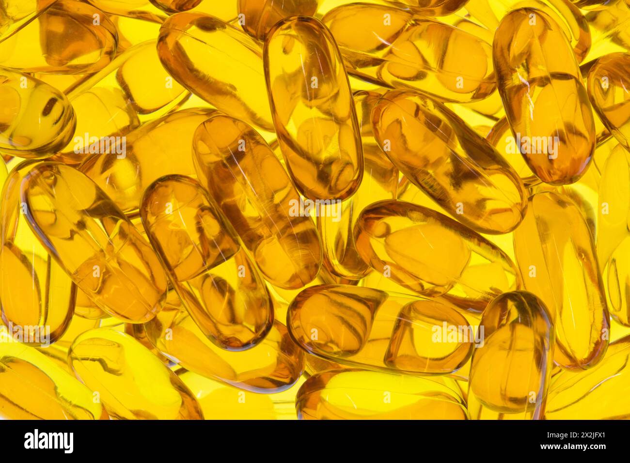 Omega 3 capsule di olio di krill di pesce integratori sparpagliati oro giallo di salute retroilluminato. Foto Stock