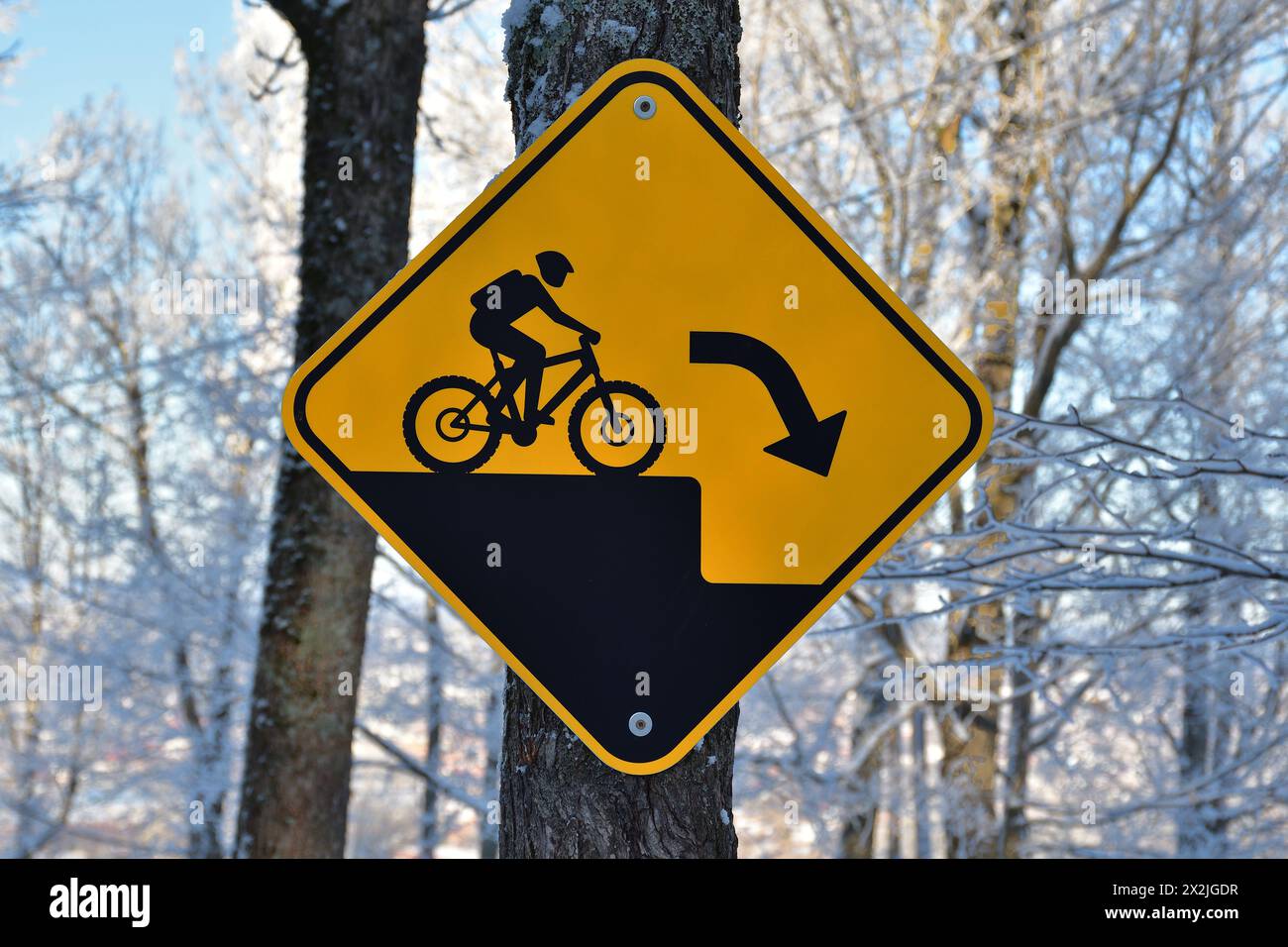 Sentiero per mountain bike, cartello di avvertimento di caduta improvvisa, cartello di avvertenza nero e giallo Foto Stock