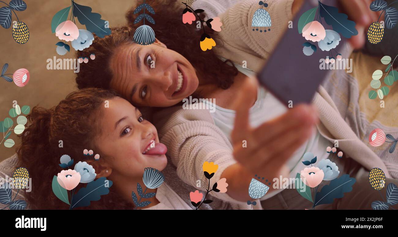 Immagine di fiori colorati su madre e figlia che creano volti, scattando selfie con lo smartphone Foto Stock