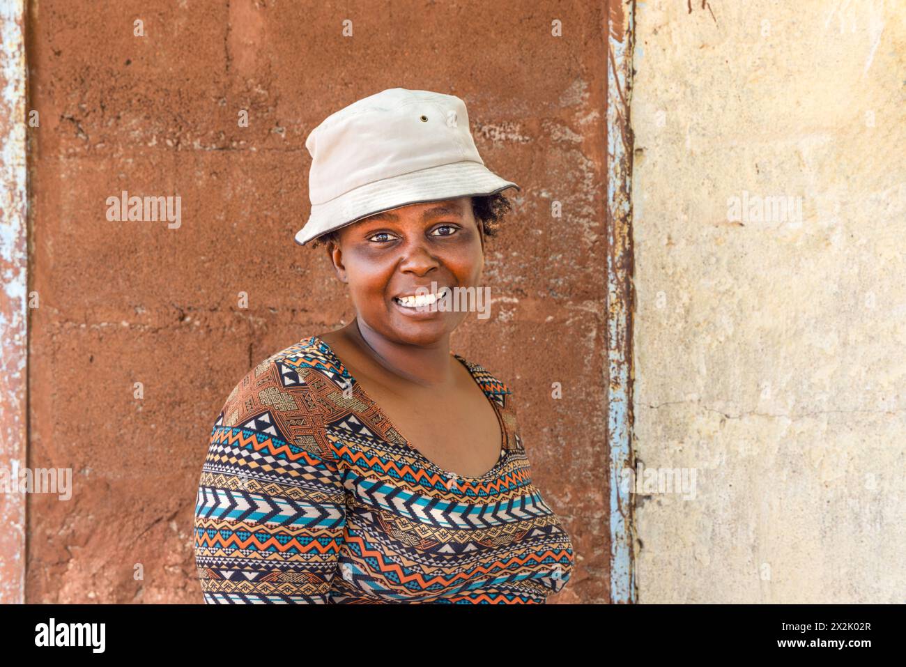 giovane donna africana con un cappello nella povera cittadina, insediamento informale Foto Stock