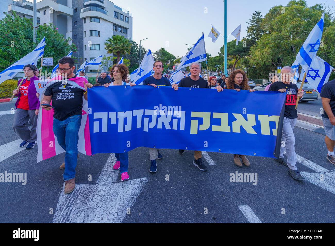 Haifa, Israele - 13 aprile 2024: Le persone (gruppo accademico) prendono parte a una marcia di protesta, con vari segni e bandiere, contro il governo, chiamando Foto Stock