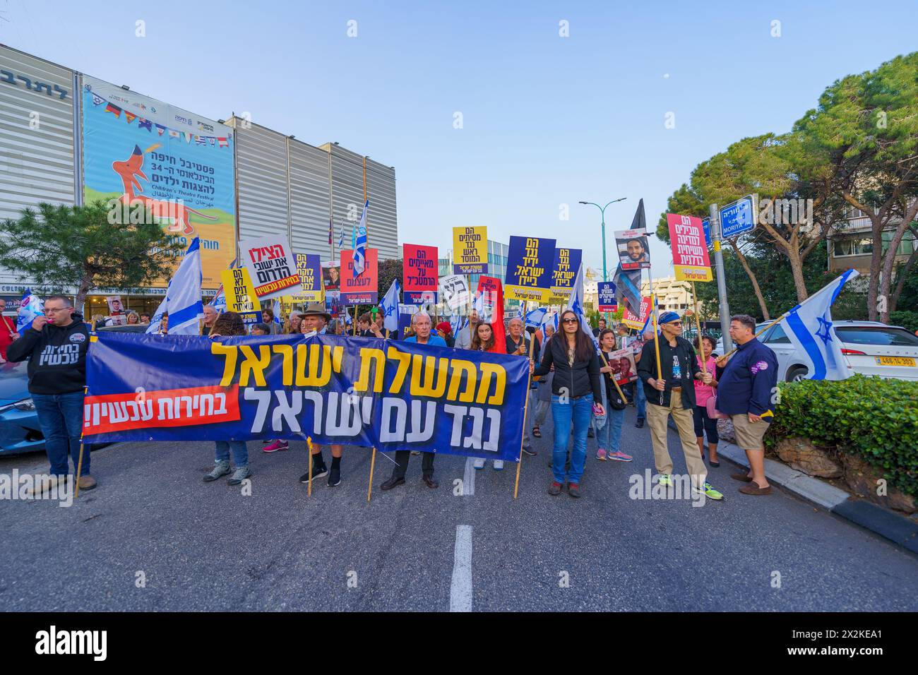 Haifa, Israele - 20 aprile 2024: La gente partecipa a una marcia di protesta, con vari segni e bandiere, contro il governo, che chiede nuove elezioni. Foto Stock