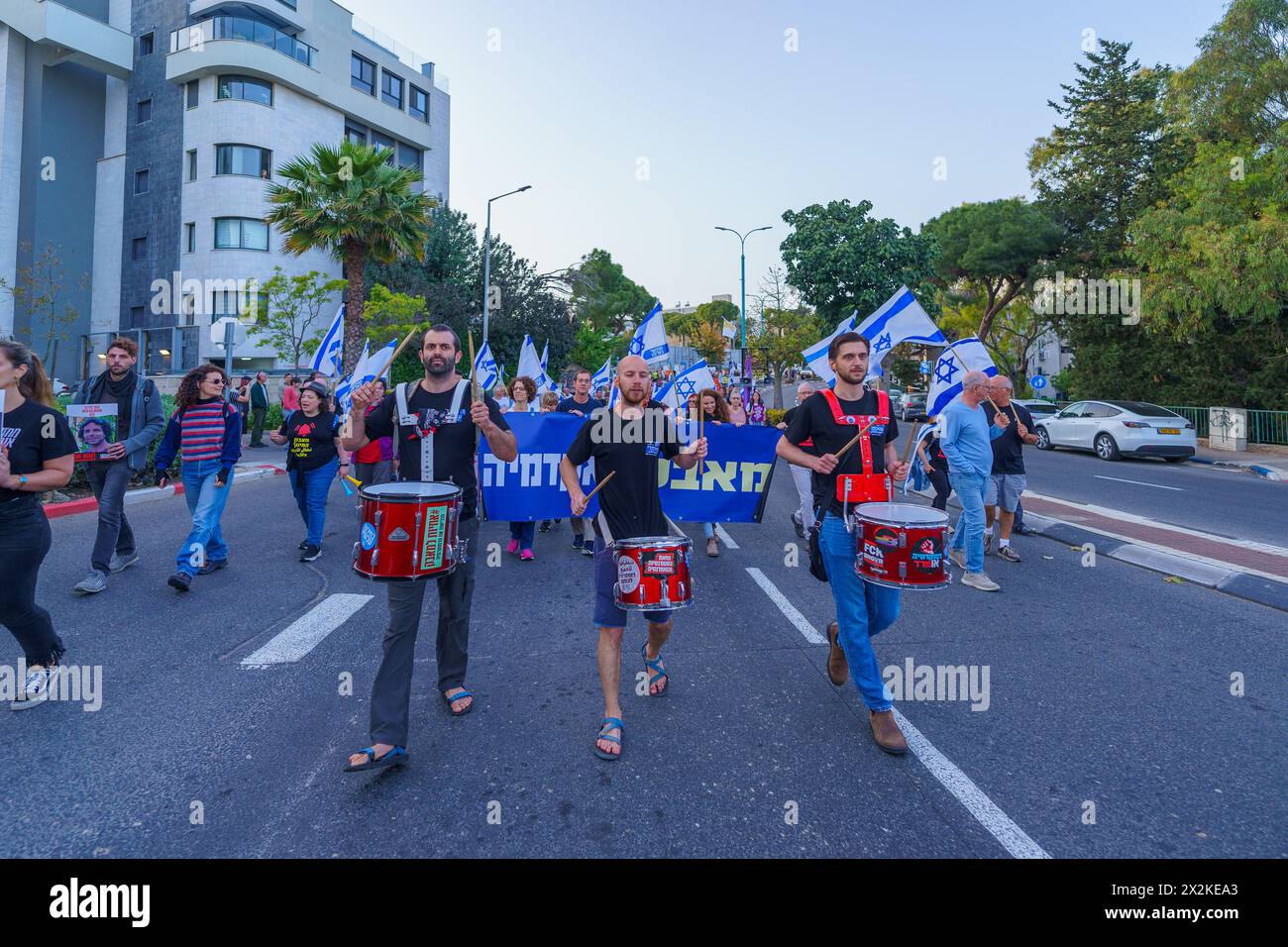 Haifa, Israele - 13 aprile 2024: Le persone (gruppo accademico) prendono parte a una marcia di protesta, con vari segni e bandiere, contro il governo, chiamando Foto Stock