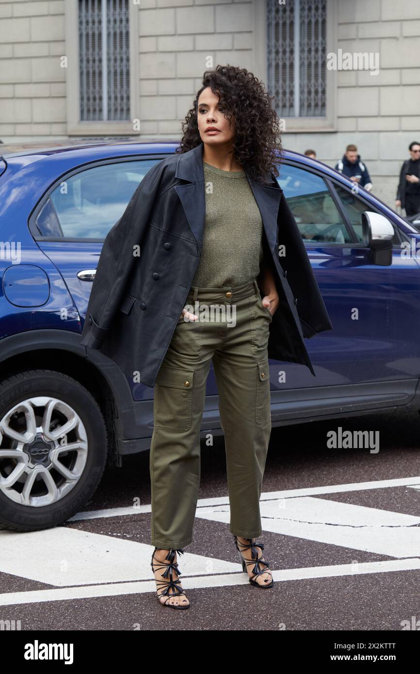 MILANO, ITALIA - 25 FEBBRAIO 2024: Donna con maglione verde oliva e pantaloni cargo prima della sfilata di Luisa spagnoli, Milano Fashion Week Street sty Foto Stock