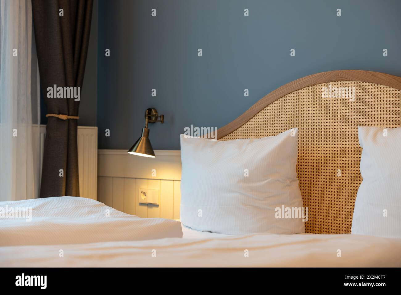 Grandi comodini con letto matrimoniale e lampade nella camera dell'hotel. Arredi per hotel. Foto Stock