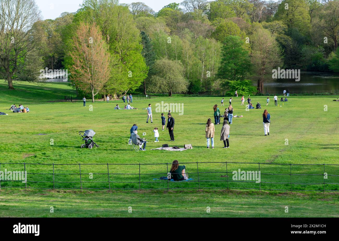 Londra. REGNO UNITO- 04.14.2023. Una folla di persone che si rilassano e si godono una giornata all'aperto sul prato verde di un parco in una bella giornata di sole primaverili. Foto Stock