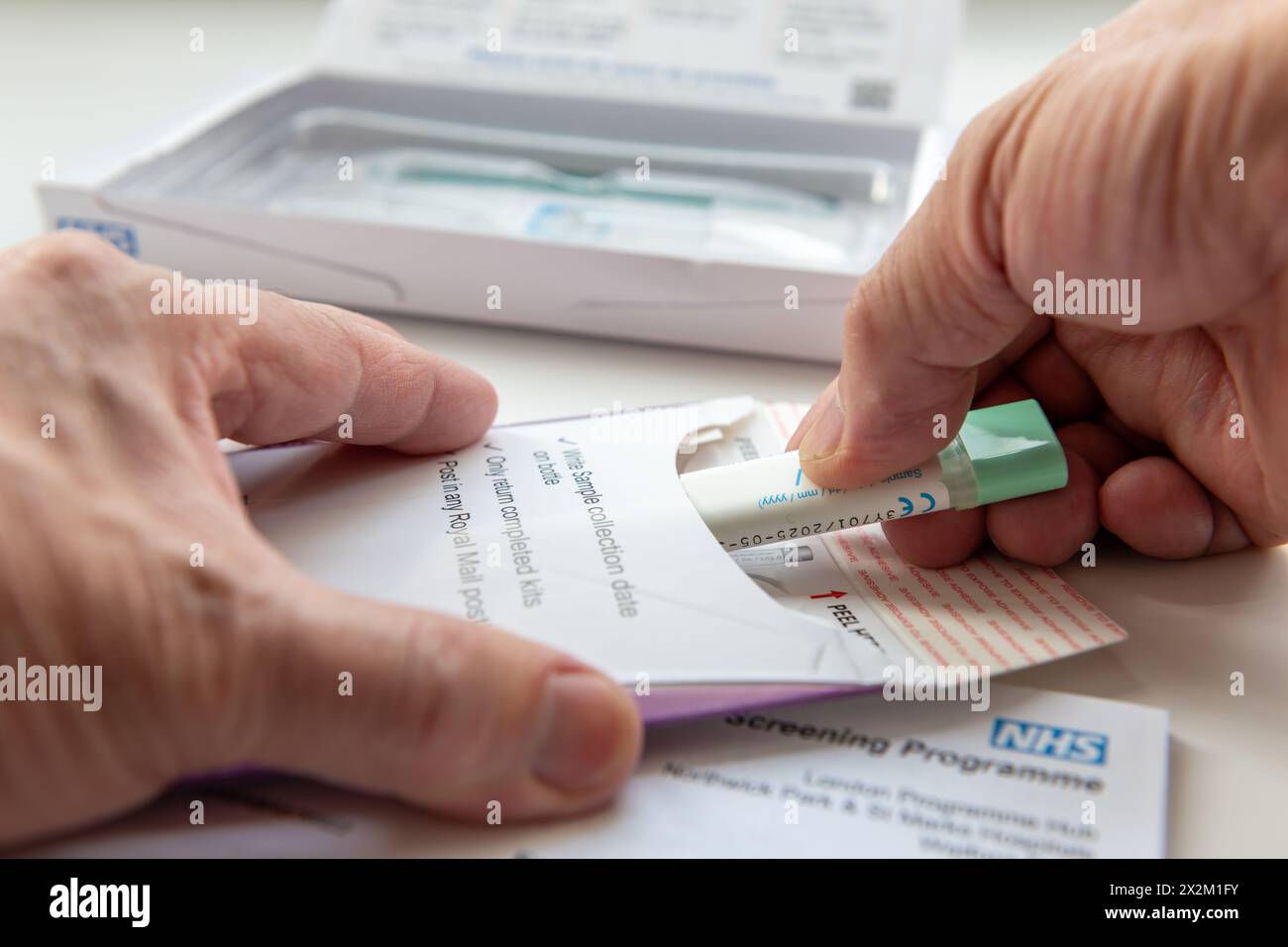 Londra. REGNO UNITO- 04.17.2024. Una persona che inserisce il campione di cancro intestinale raccolto nella busta da inviare per l'analisi. Foto Stock
