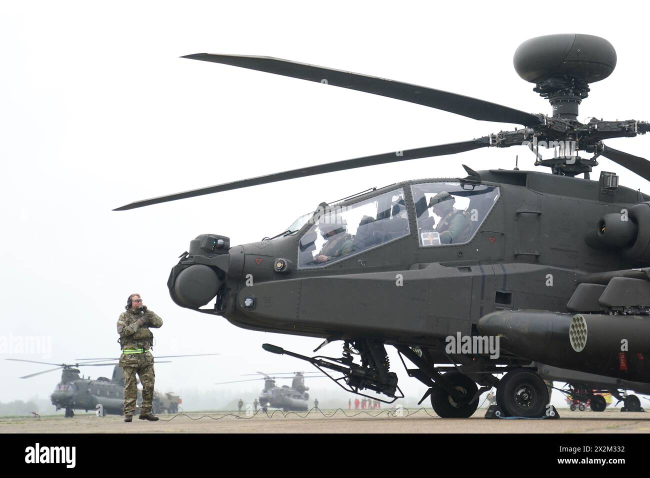 Gli elicotteri d'attacco Apache AH-64E dell'esercito britannico sono pronti per il decollo dalla stazione aerea di Wattisham nel Suffolk, prima di dirigersi in Estonia per addestrarsi insieme agli alleati della NATO nell'esercitazione Steadfast Defender 24. Alla flotta di nuovi elicotteri d'attacco si uniranno elicotteri da ricognizione Wildcat e elicotteri di supporto RAF Chinook (a sinistra) per unirsi a un esercizio di addestramento NATO in Finlandia. Gli Apache voleranno missioni d'attacco a sostegno dell'addestramento su larga scala dell'esercito finlandese, prima di dirigersi verso l'Estonia per un ulteriore esercizio dove saranno raggiunti da più elicotteri britannici. L'esercizio di formazione con Foto Stock