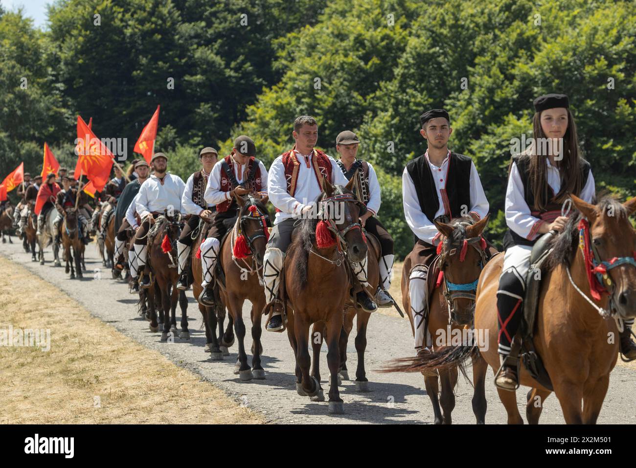 A Illinden (Festa della Repubblica), i ciclisti vestiti tradizionalmente viaggiano da Skopje, la capitale, a Meckin. Kamen, Macedonia del Nord Foto Stock