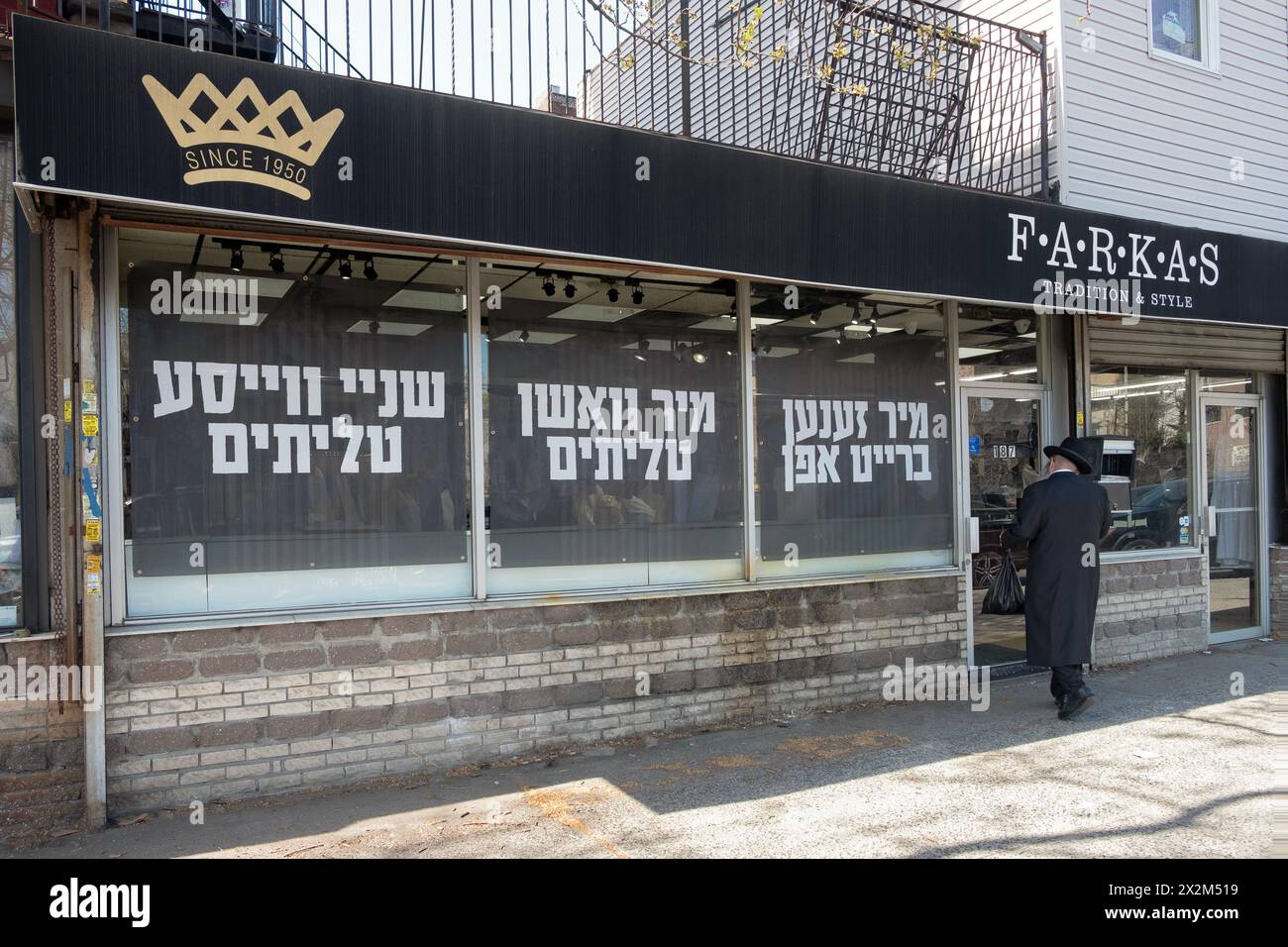 L'esterno di Farkas Judaica a Williamsburg con grandi cartelli yiddish nelle finestre sulla pulizia degli scialli di preghiera. Su Rodney Street, 2024. Foto Stock
