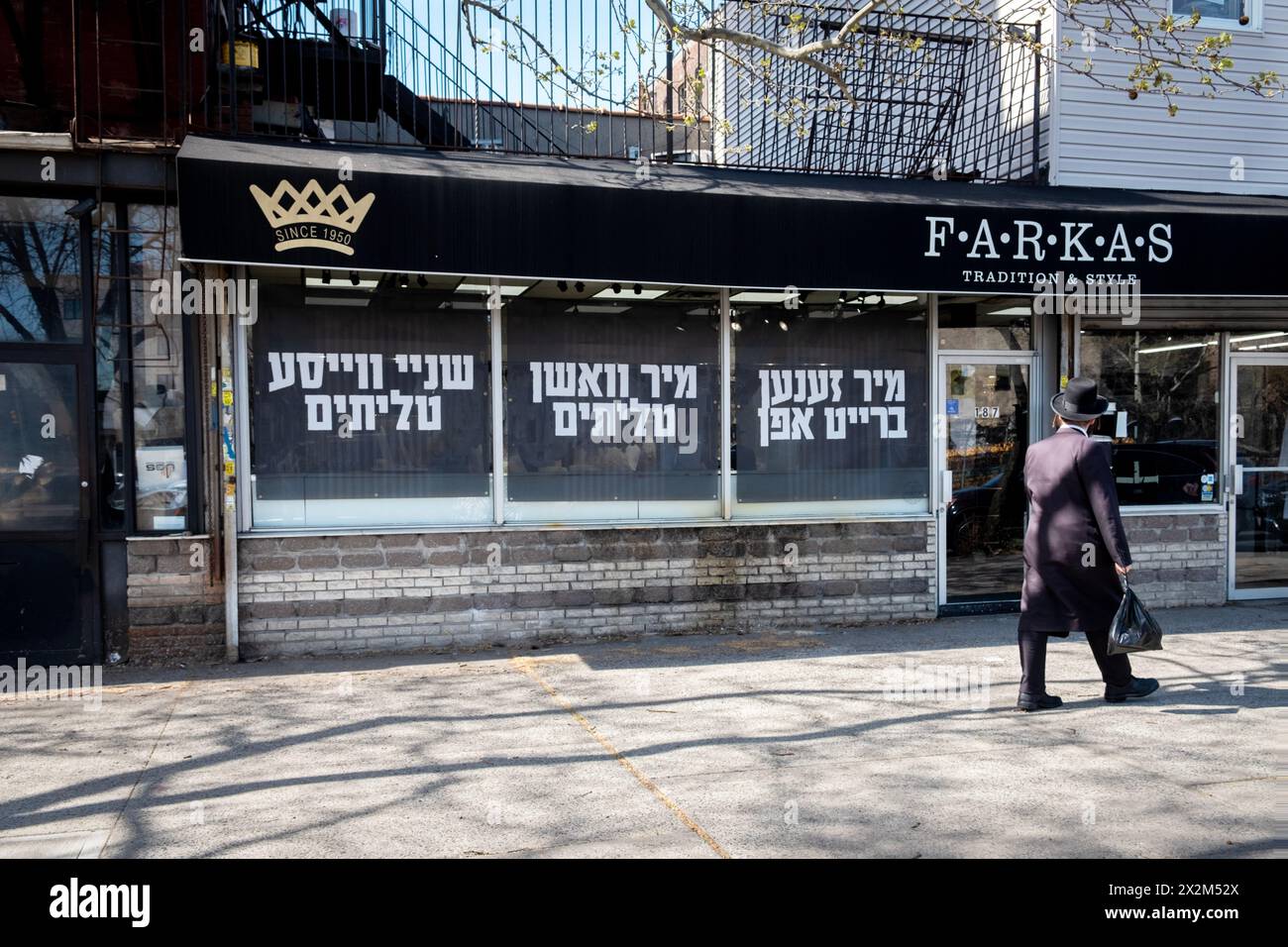 L'esterno di Farkas Judaica a Williamsburg con grandi cartelli yiddish nelle finestre sulla pulizia degli scialli di preghiera. Su Rodney Street, 2024. Foto Stock