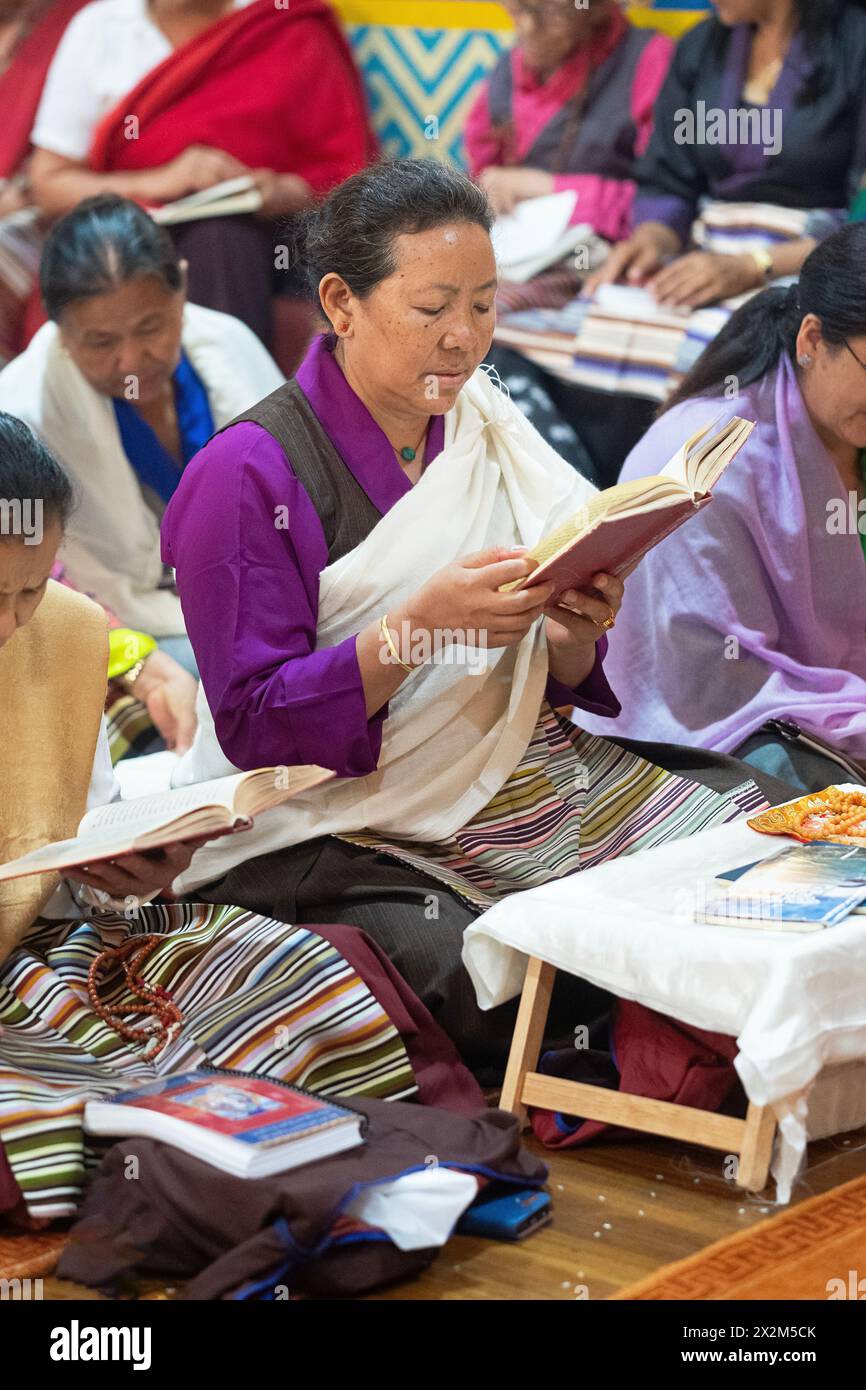 Le devote donne buddiste leggono da un libro di preghiere durante una cerimonia presso il tempio Sherpa Kyidug di New York. Foto Stock