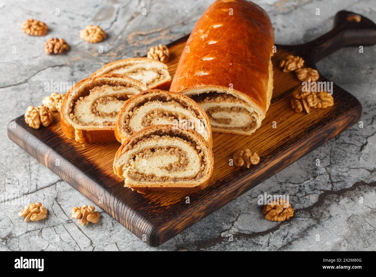 Rotoli di noci natalizi e pasquali dell'Europa orientale realizzati con un primo piano di noci macinate sulla tavola di legno. Orizzontale Foto Stock