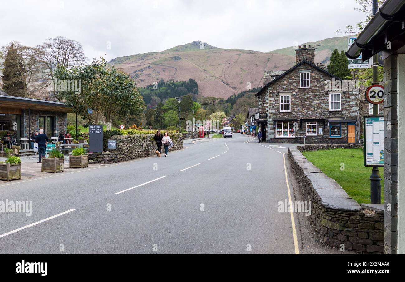 Camminate e turisti passeggiano attraverso il villaggio di Grasmere nel Parco Nazionale del Lake District, Cumbria, Inghilterra, Regno Unito Foto Stock