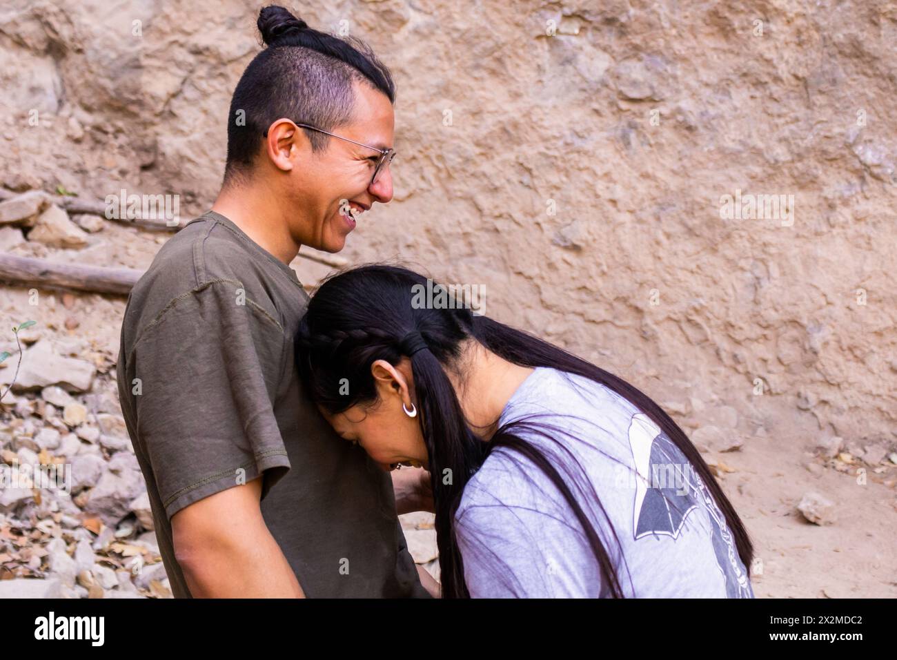 Una coppia felice che condivide un momento leggero con sorrisi genuini in un ambiente all'aperto Foto Stock