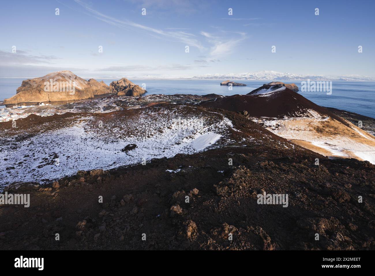 Vista maestosa della costa frastagliata dell'Islanda con macchie di neve e cieli azzurri Foto Stock