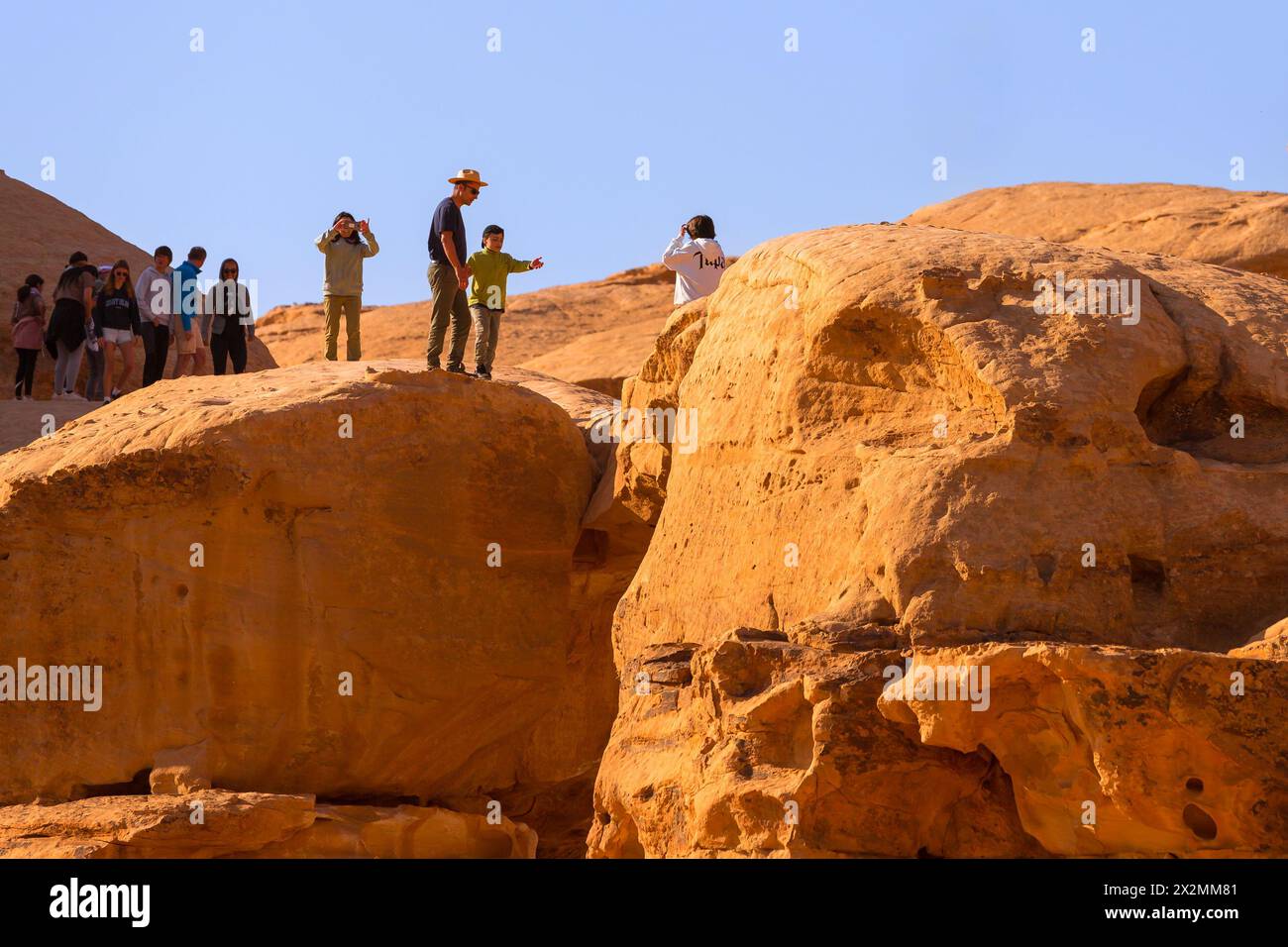 Giordania, Wadi Rum - 2 novembre 2022: Famoso deserto punto di riferimento Burdah Arch Rock Bridge e la gente Foto Stock