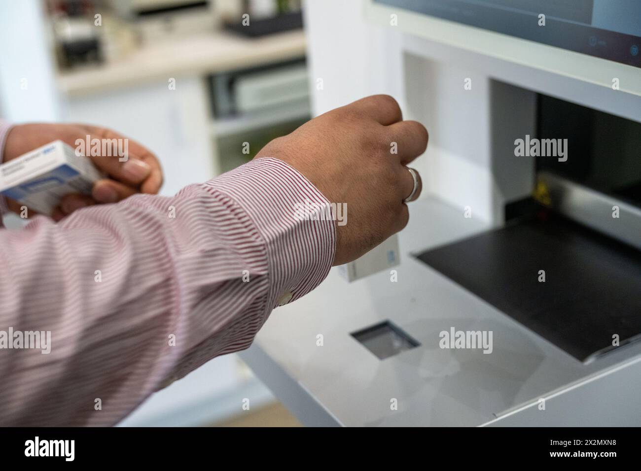 SYMBOL - 23 aprile 2024, Baviera, Breitengüßbach: Un farmacista esegue la scansione di un farmaco per il magazzino presso un distributore automatico. Sempre più farmacie si rivolgono all'automazione. (A dpa 'il numero di farmacie continua a diminuire') foto: Pia Bayer/dpa Foto Stock