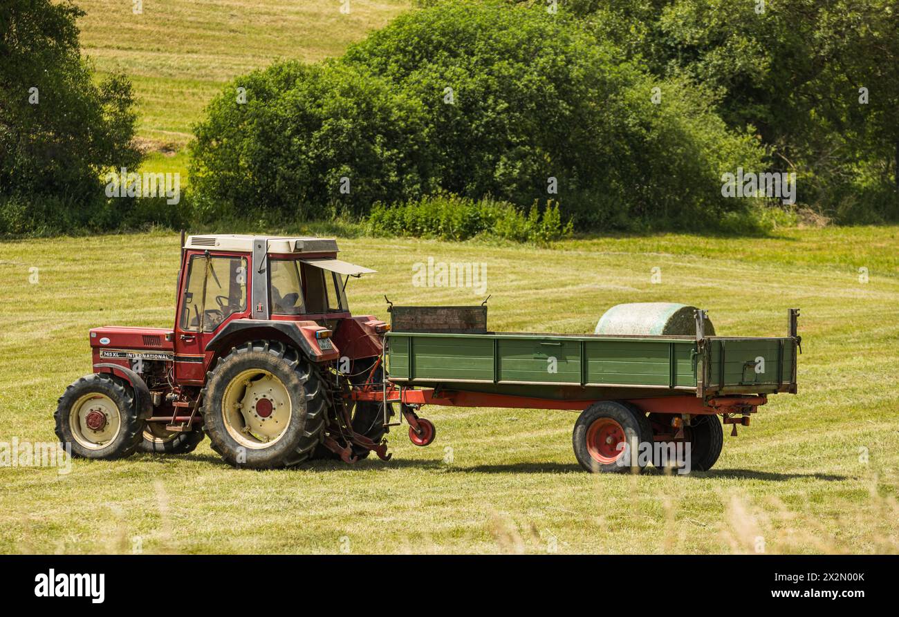 Ein Bauer ist mit seinem Traktor daran die Heuballen ins trockene zu bringen. Es ist der Vorrat für die Viehversorgung im Winter. (Bonndorf, Deutschla Foto Stock