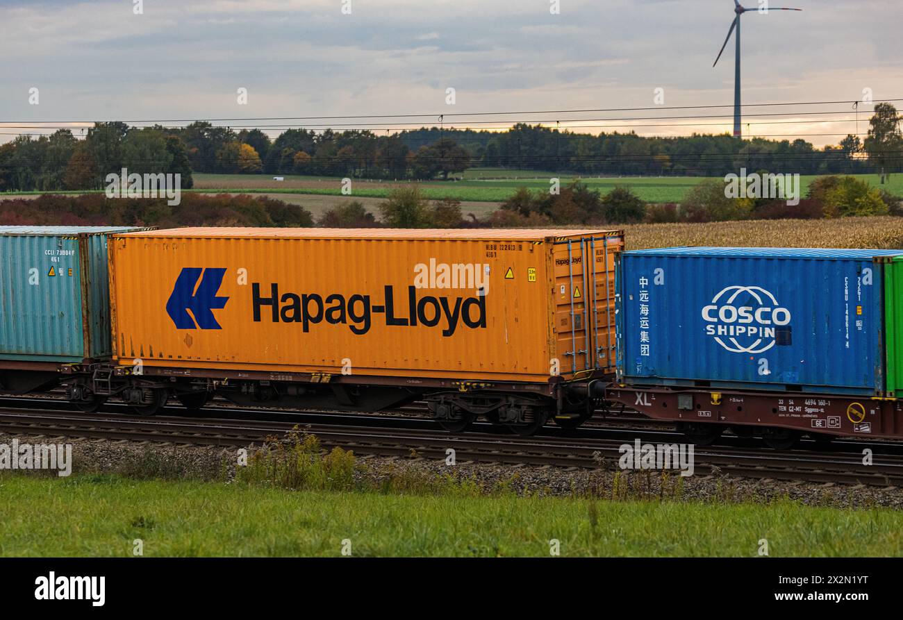 Schiffscontainer von Hapag-Lloyd und Cosco Shipping werden auf einem Güterzug auf der Bahnstrecke zwischen München und Nürnberg durch Deutschland tran Foto Stock