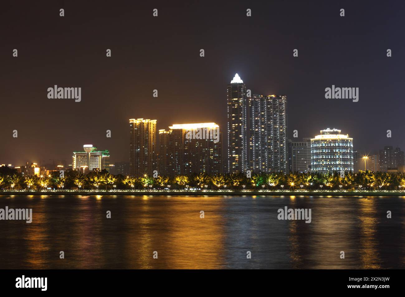 Costa con alti edifici con illuminazione al neon vicino al fiume Pearl di notte a Guangzhou, Cina Foto Stock
