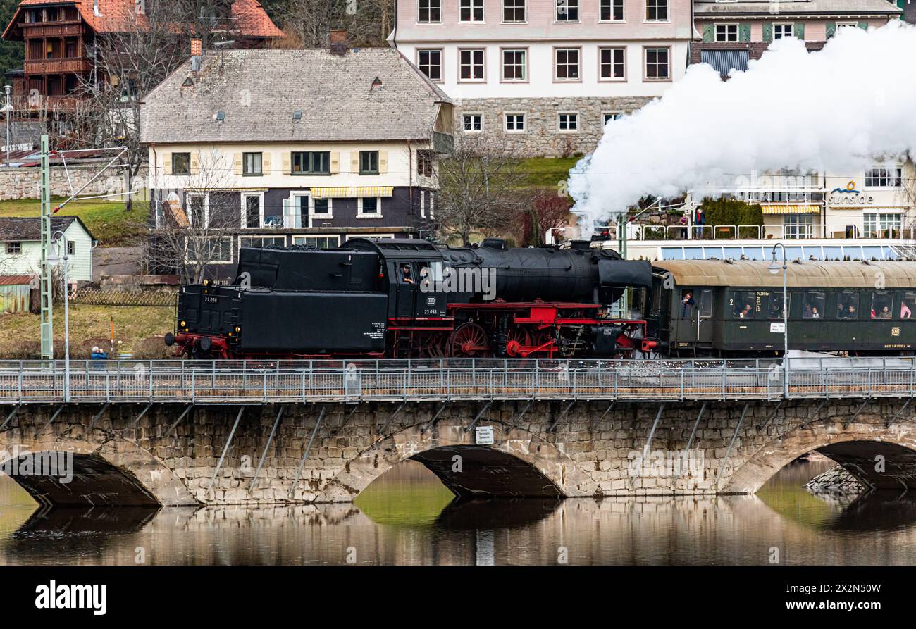 Die Dampflokomotive BR 23 fährt aus dem Bahnhof Schluchsee hinaus und entlang dem gleichnamigen SEE durch den Schwarzwald. Die Passagiere befinden sic Foto Stock