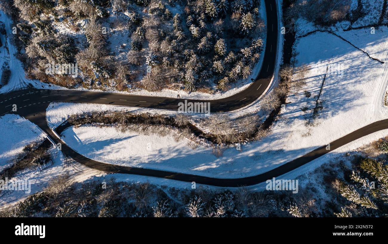 Eine Strasse führt durch die Winterlandschaft im Schwarzwald. (Bonndorf im Schwarzwald, Deutschland, 17.12.2022) Foto Stock