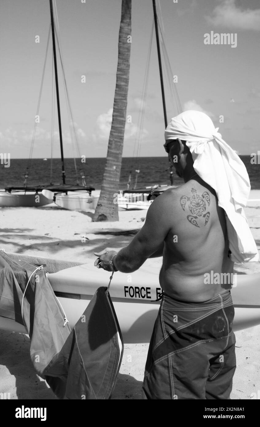 Uomo che copre la barca a vela con telo al porticciolo di Fort Lauderdale, Florida, Stati Uniti. Foto Stock