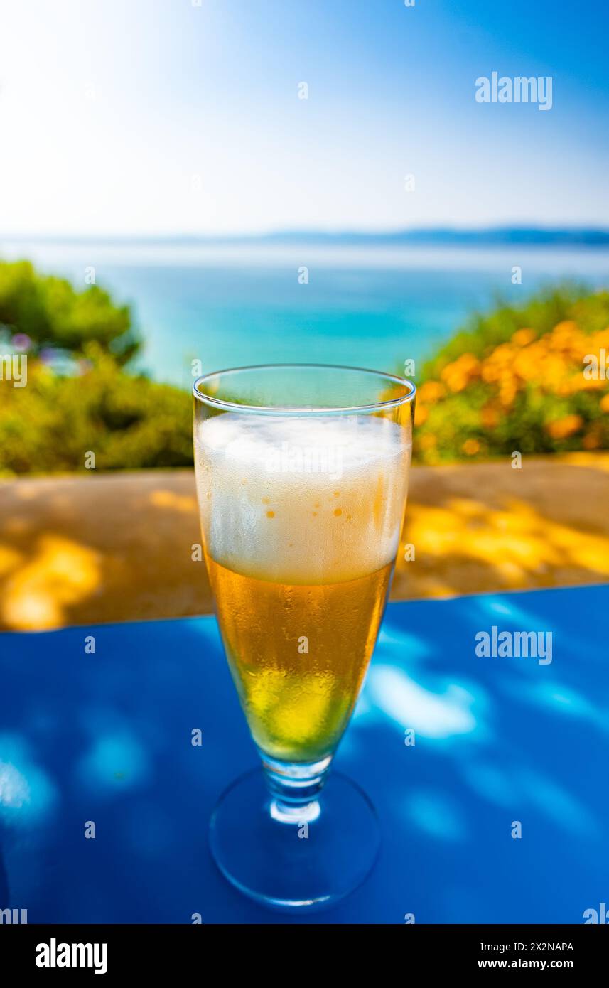 Un bicchiere di birra fredda su un tavolo in un paese caldo durante le vacanze. Foto Stock