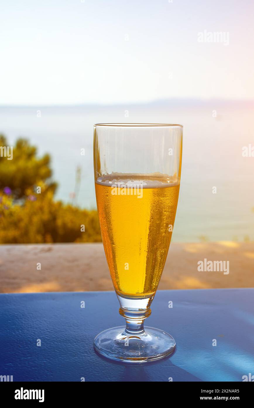 Un bicchiere di birra fredda su un tavolo in un paese caldo durante le vacanze. Foto Stock