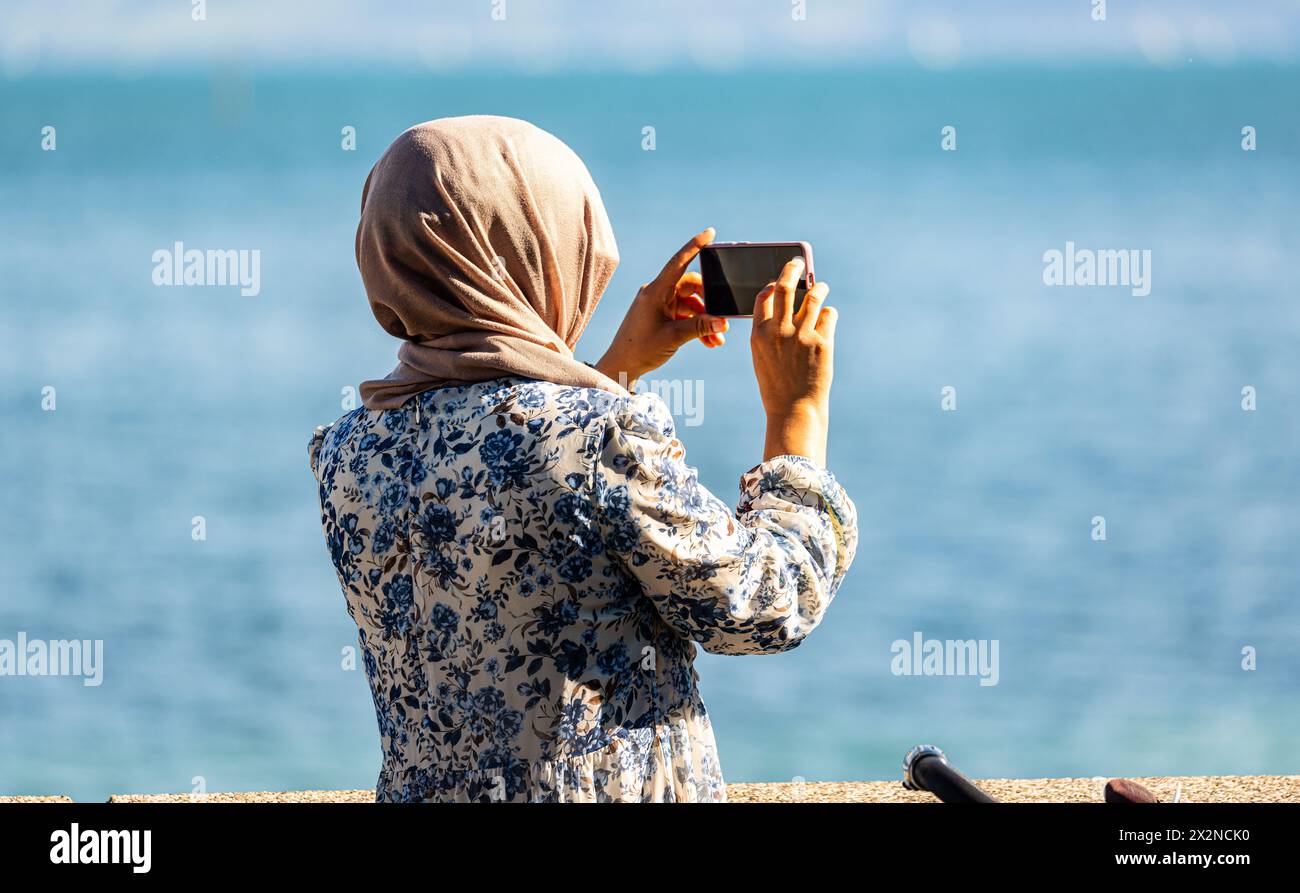 Eine ‹ma macht ein foto einer Sehenswürdigkeit am Bodensee. (Friedrichshafen, Deutschland, 21.08.2022) Foto Stock