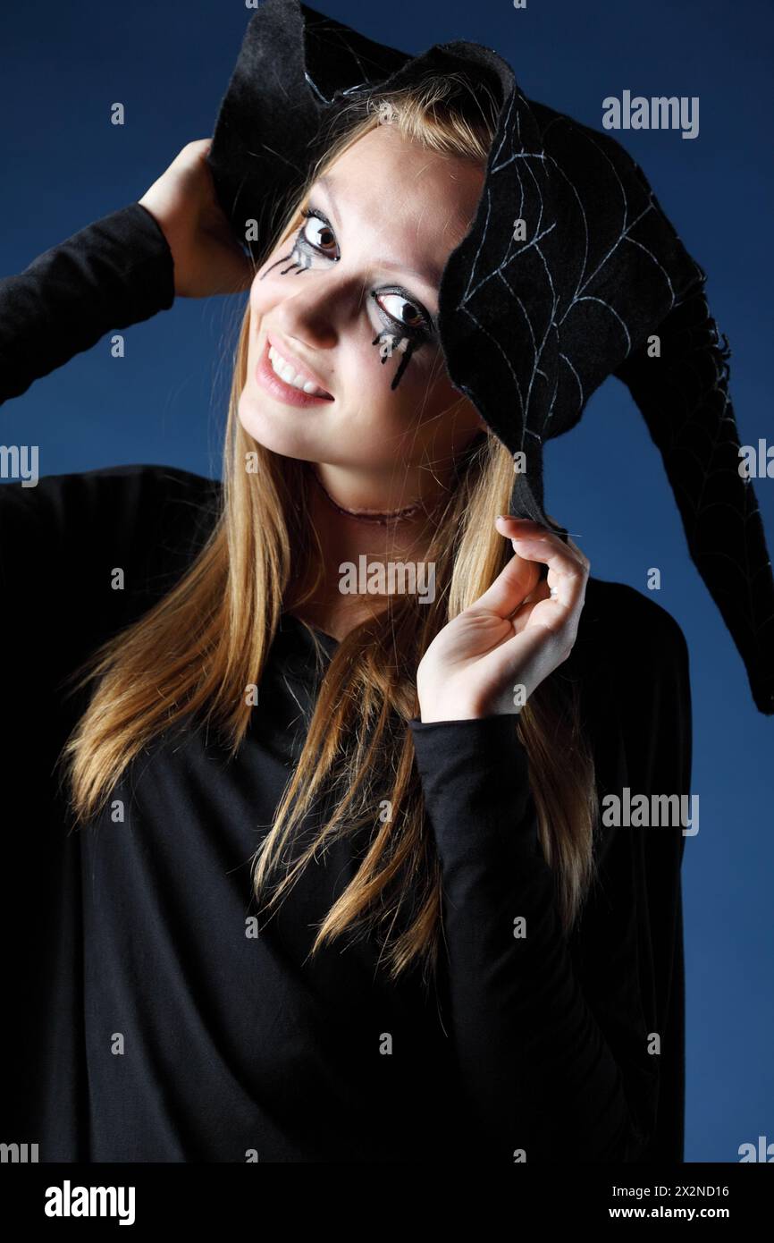 Zombie sorridente con lacrime nere e gola tagliata in un grande cappello nero. Foto Stock