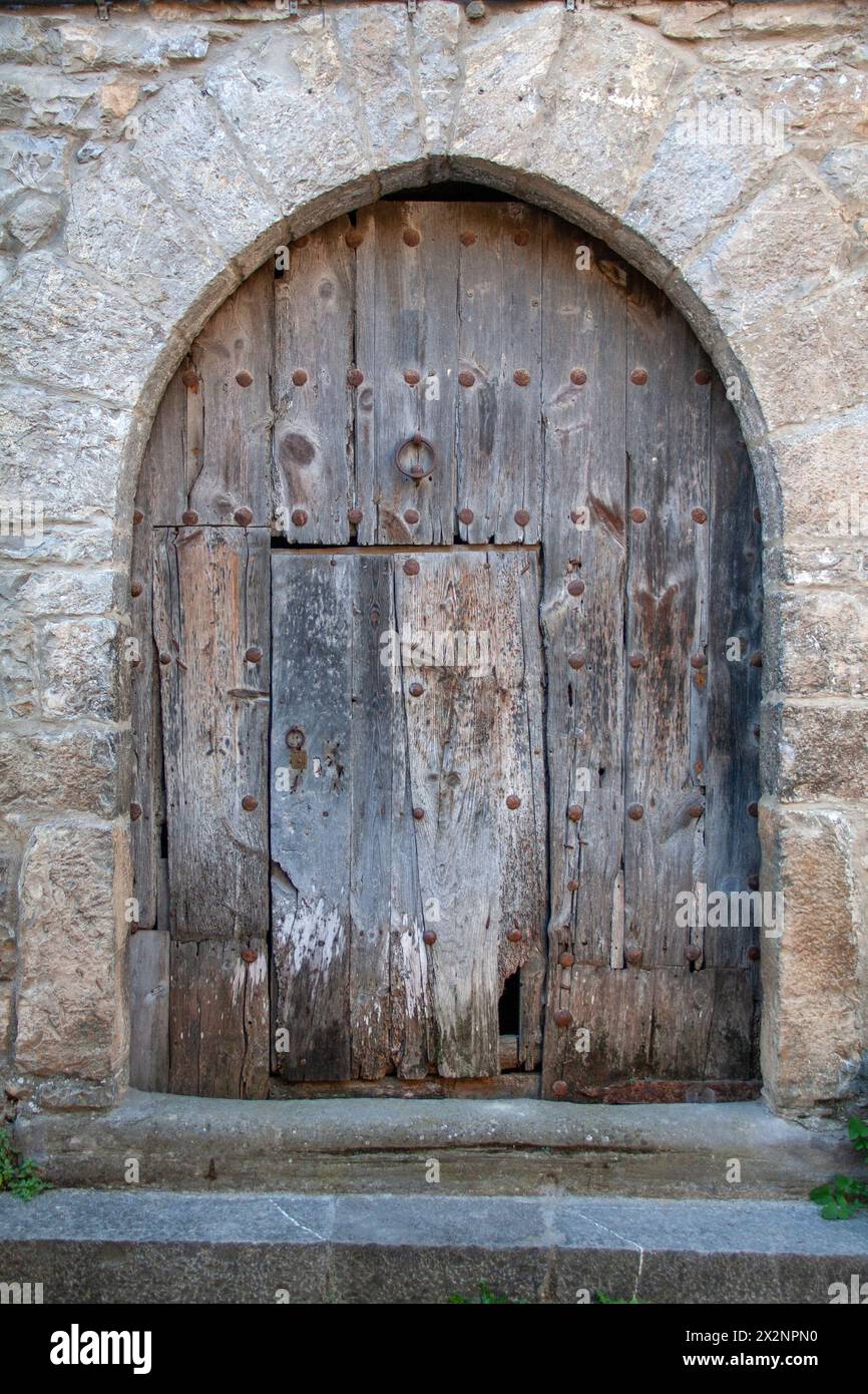 Ainsa, antica porta d'ingresso in legno sotto un muro a volta ogivale Foto Stock